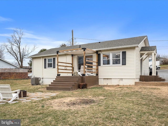 view of front of home with central AC and a front yard