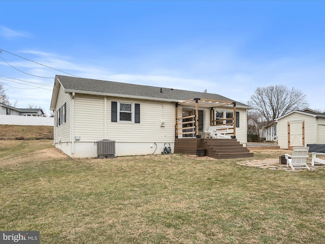 back of property featuring a storage shed, a yard, and central air condition unit