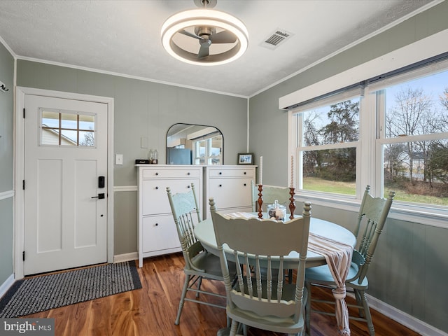 dining room with crown molding and dark hardwood / wood-style flooring