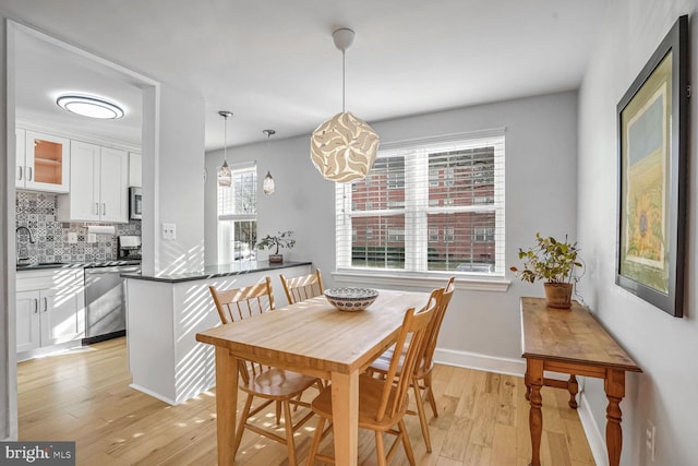 dining space featuring sink and light hardwood / wood-style flooring