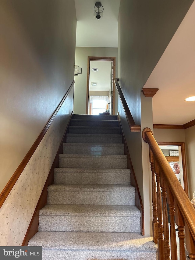 staircase featuring crown molding