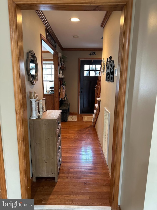 entryway with dark wood-type flooring and ornamental molding