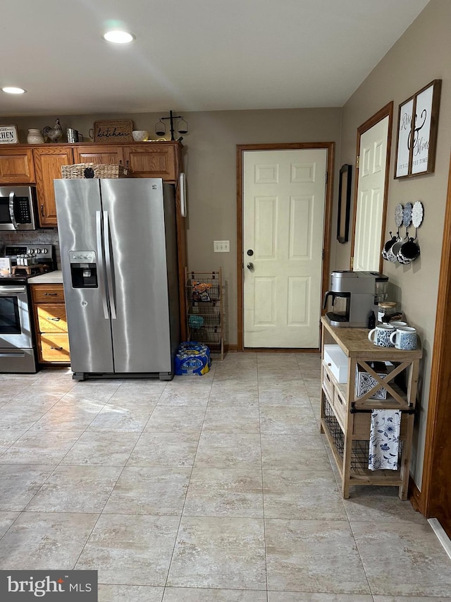 kitchen with light tile patterned flooring and appliances with stainless steel finishes