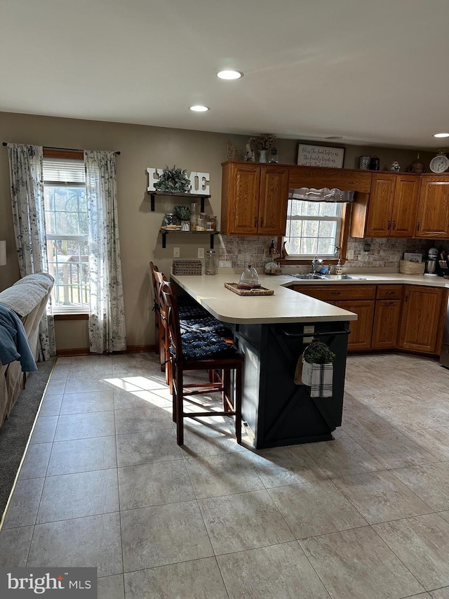 kitchen featuring sink, decorative backsplash, and a breakfast bar area