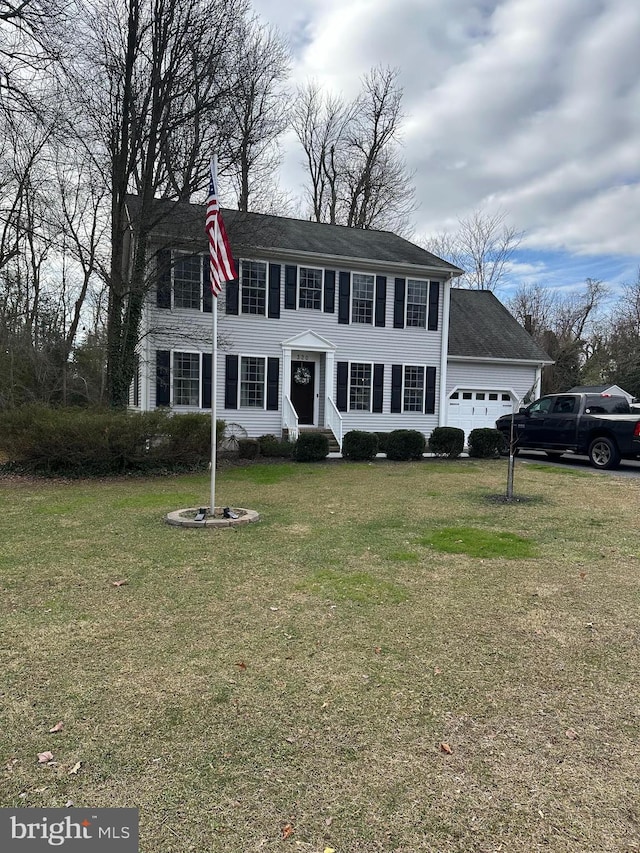 colonial house with a garage and a front lawn