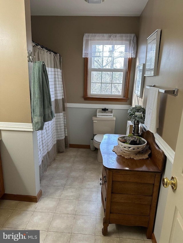 bathroom featuring tile patterned floors, vanity, toilet, and curtained shower