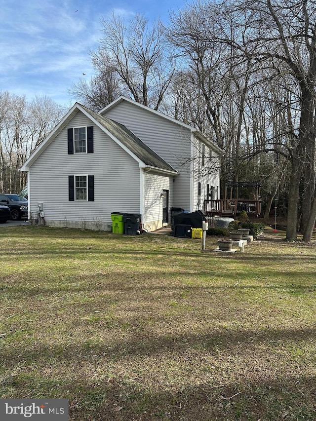 view of home's exterior with a wooden deck and a yard