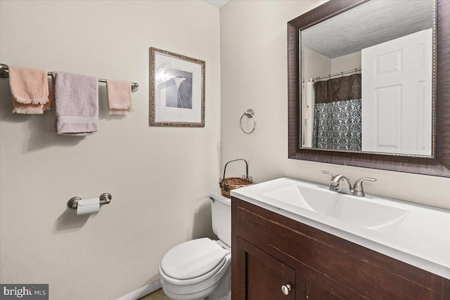 bathroom with vanity, a textured ceiling, and toilet