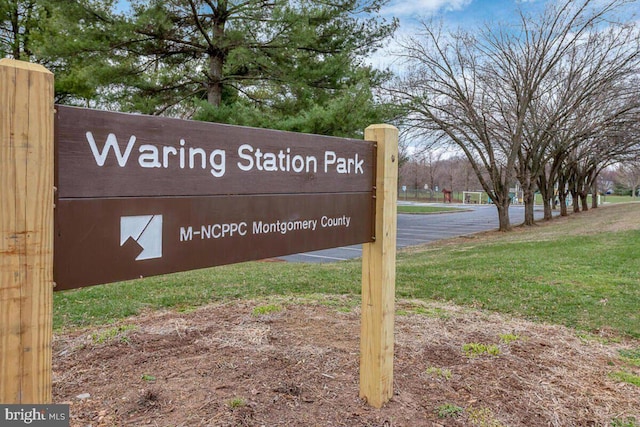 community / neighborhood sign featuring a yard