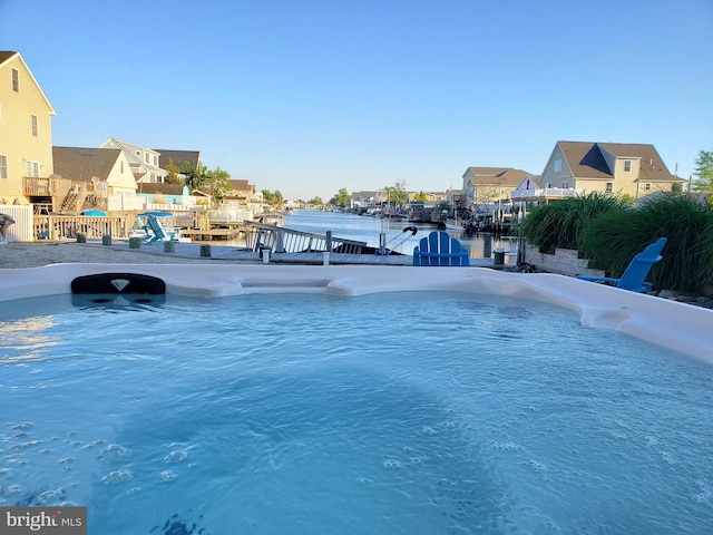 view of pool featuring a boat dock and a water view