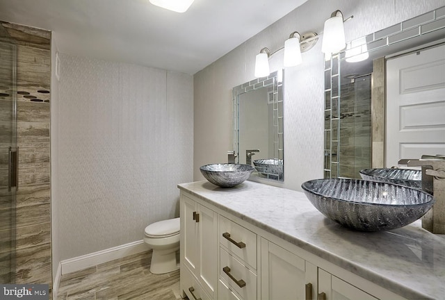 bathroom featuring hardwood / wood-style flooring, vanity, toilet, and walk in shower