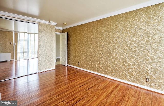 unfurnished bedroom with hardwood / wood-style flooring and crown molding