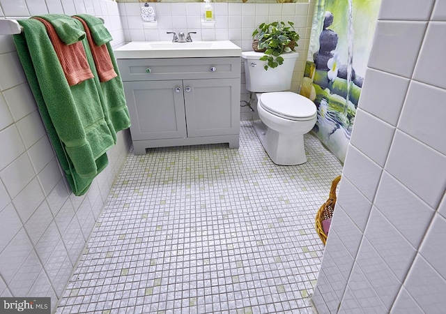 bathroom with vanity, toilet, tile walls, and a shower with curtain