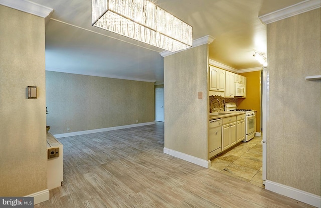 kitchen featuring white appliances, ornamental molding, sink, and light hardwood / wood-style flooring