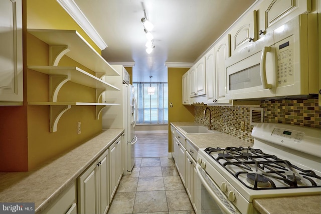 kitchen with light tile patterned flooring, sink, crown molding, white appliances, and backsplash