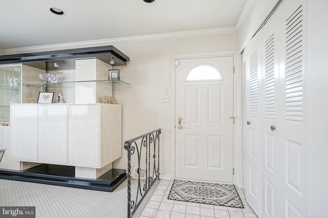 foyer with light tile patterned floors and crown molding