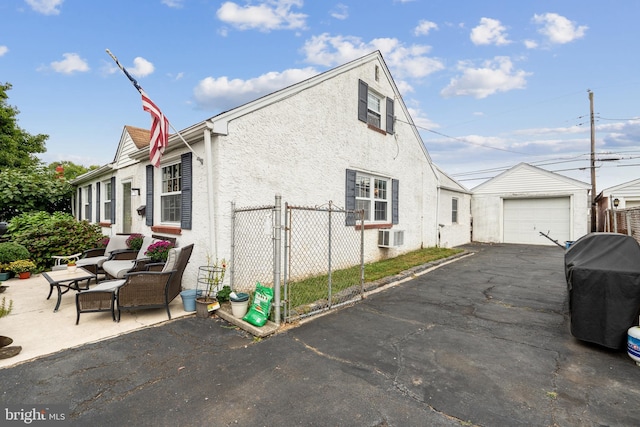 view of side of home with a garage, an outdoor structure, and a wall unit AC