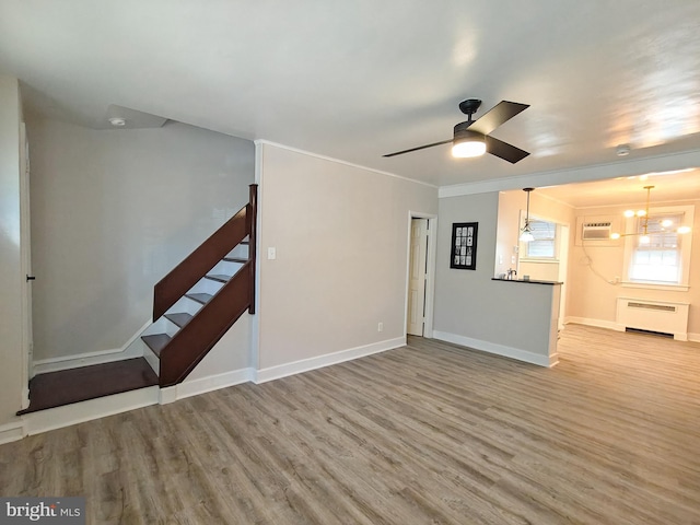 unfurnished living room featuring crown molding, light hardwood / wood-style flooring, an AC wall unit, radiator heating unit, and ceiling fan