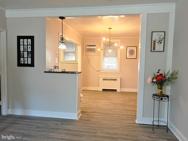 dining space featuring a chandelier, an AC wall unit, ornamental molding, radiator heating unit, and hardwood / wood-style floors