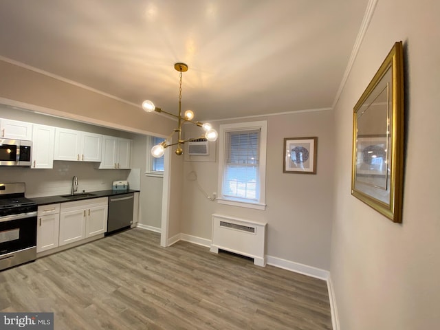 kitchen featuring pendant lighting, appliances with stainless steel finishes, sink, and white cabinets