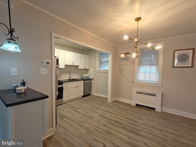 kitchen featuring pendant lighting, sink, dishwasher, ornamental molding, and white cabinets