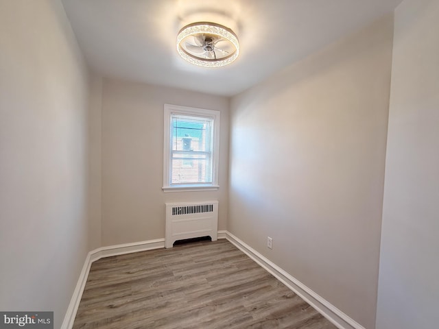 spare room featuring radiator and light wood-type flooring