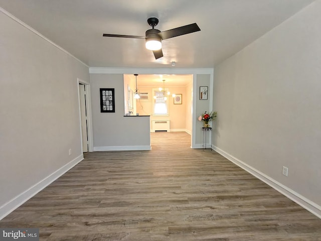 unfurnished living room featuring ceiling fan with notable chandelier, crown molding, and hardwood / wood-style floors