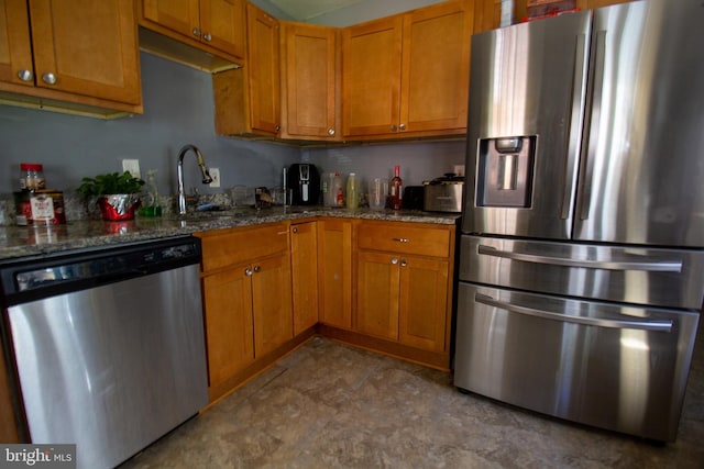 kitchen featuring stainless steel appliances, sink, and stone counters