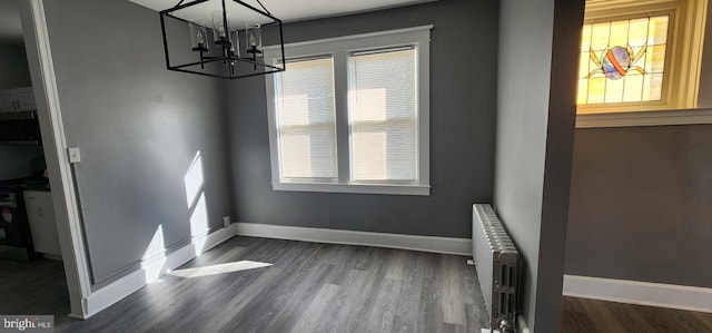 dining area with a notable chandelier, radiator heating unit, and dark hardwood / wood-style floors