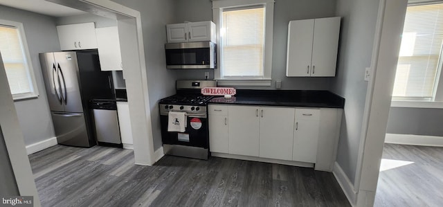 kitchen featuring stainless steel appliances, dark hardwood / wood-style floors, and white cabinets