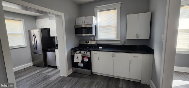 kitchen featuring appliances with stainless steel finishes, dark hardwood / wood-style flooring, and white cabinets