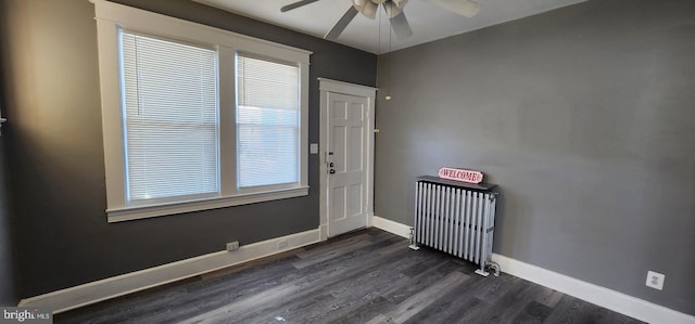 interior space featuring ceiling fan, dark wood-type flooring, radiator heating unit, and a wealth of natural light