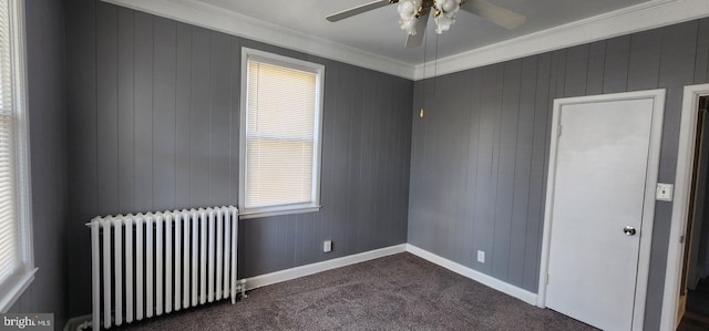 unfurnished room with ceiling fan, ornamental molding, radiator heating unit, and dark colored carpet