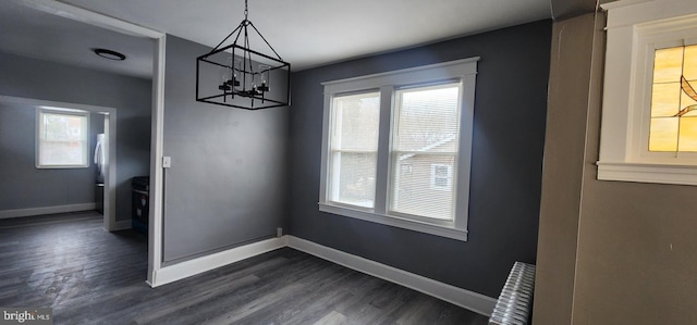 unfurnished dining area featuring radiator and dark wood-type flooring