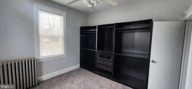 interior space with ceiling fan, a closet, radiator heating unit, and multiple windows