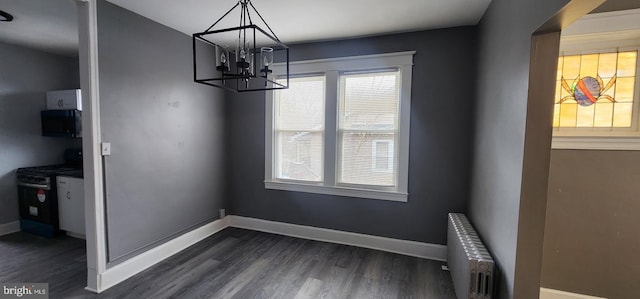 unfurnished dining area with radiator, a wealth of natural light, and dark hardwood / wood-style floors