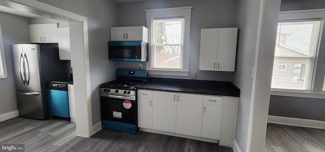 kitchen featuring stainless steel appliances, dark hardwood / wood-style floors, and white cabinets