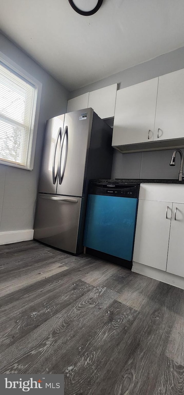 kitchen with stainless steel fridge, white cabinetry, dark wood-type flooring, and dishwashing machine