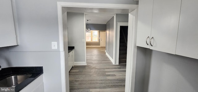 hallway with hardwood / wood-style flooring and sink