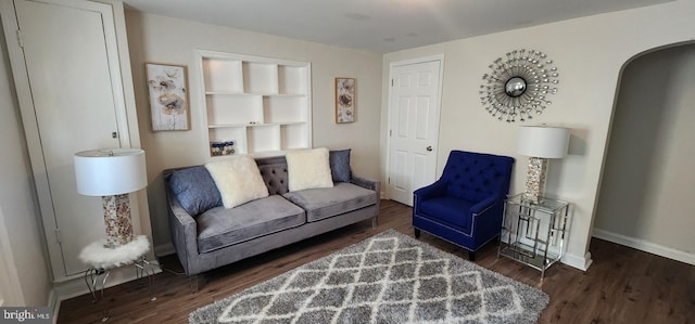 living room with dark hardwood / wood-style floors and built in features