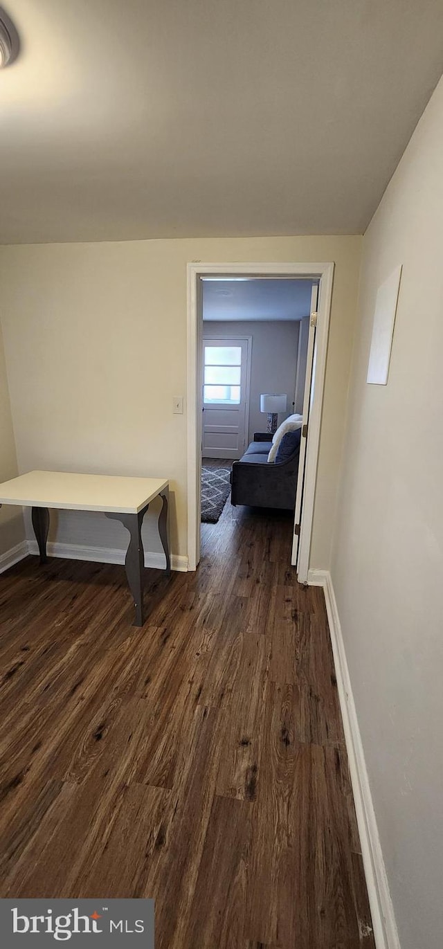 hallway with dark hardwood / wood-style flooring