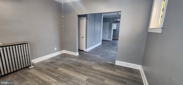 corridor with radiator heating unit and dark hardwood / wood-style flooring