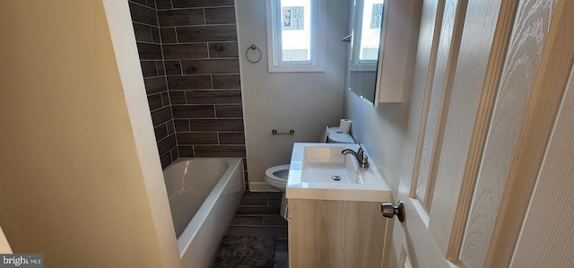 full bathroom featuring vanity, tiled shower / bath combo, and toilet