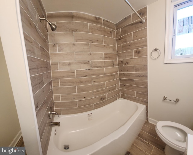 bathroom with tiled shower / bath and toilet