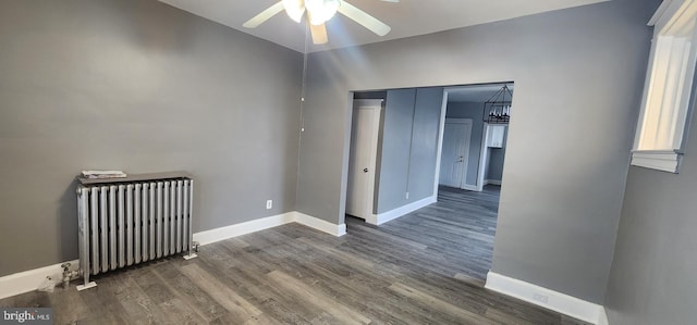 unfurnished room featuring ceiling fan, radiator heating unit, and dark hardwood / wood-style flooring