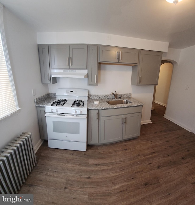 kitchen featuring white range with gas cooktop, radiator, gray cabinetry, and sink