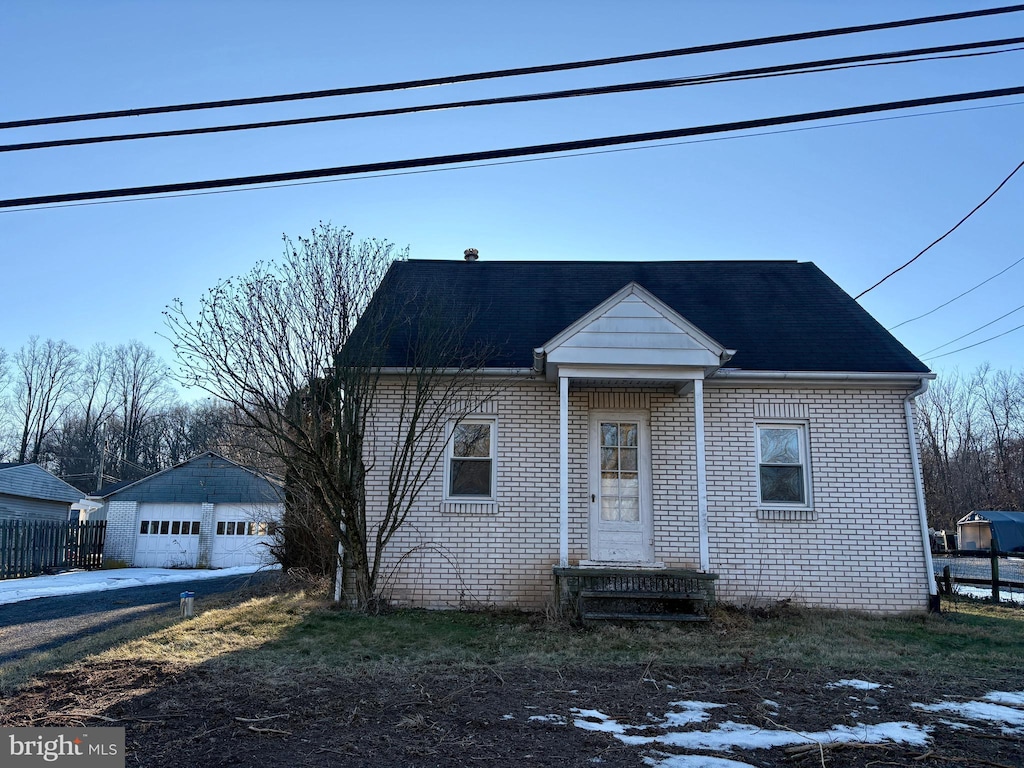 view of front of property featuring a garage and an outdoor structure