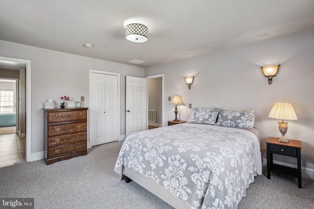 bedroom with light colored carpet and a closet