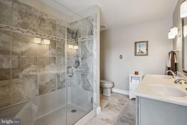 bathroom with vanity, toilet, and a shower with door