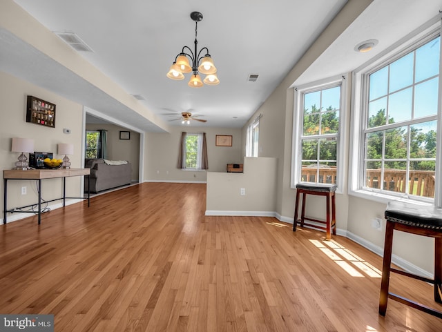 dining area featuring ceiling fan with notable chandelier and light hardwood / wood-style floors